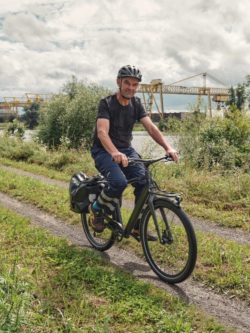 Arbeiter fährt auf JobRad zur Arbeit durchs Grüne