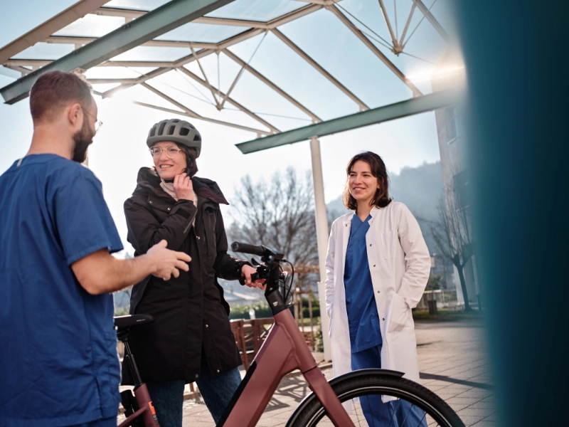 Zwei Pfleger:innen im Gespräch mit einer JobRadlerin