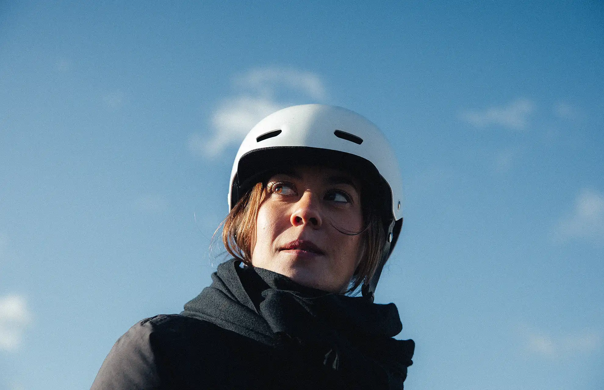 Junge Frau mit weißem Fahrradhelm schaut konzentriert